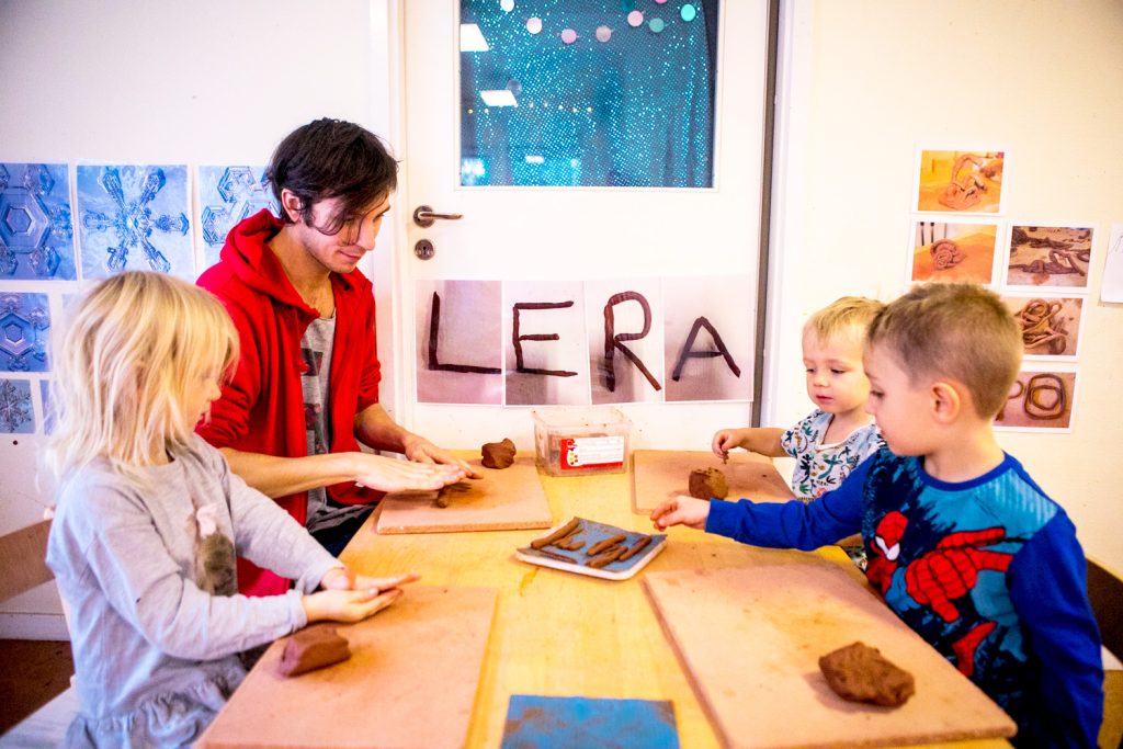 En pedagog och tre barn skapar saker i lera på en förskola i Hammarbyhöjden. Foto